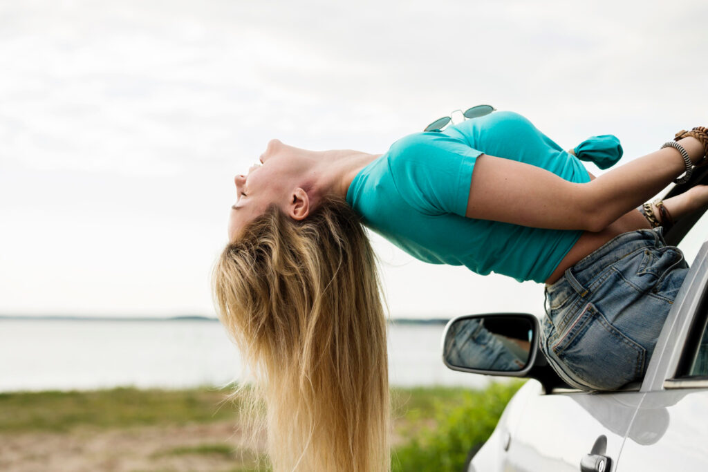 Woman hanging her head out of a car window
