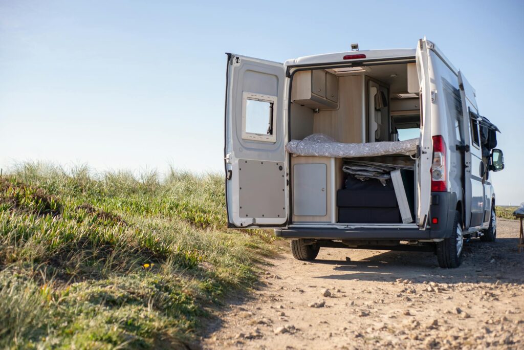 Campervan with doors open on a dirt road