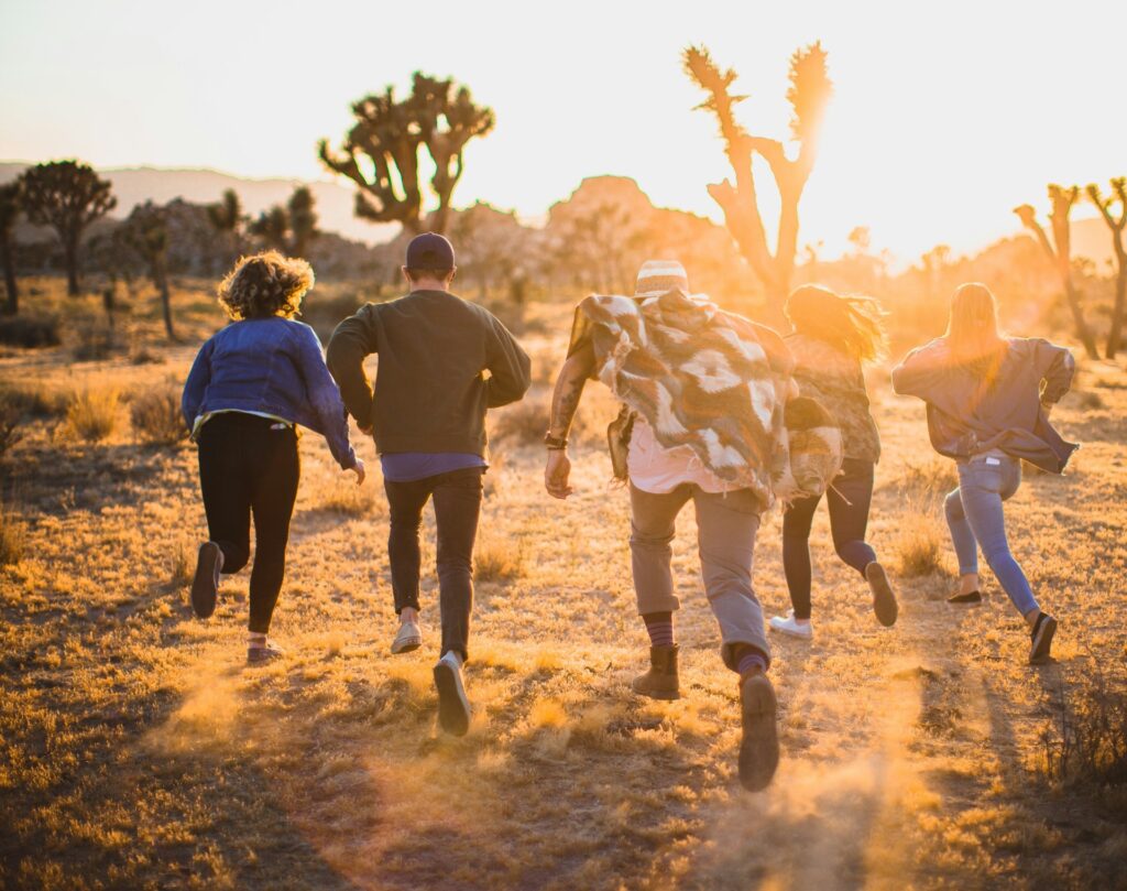 Group of people running through trees in the desert